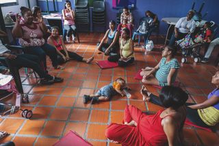 A group of women, some pregnant, some with children, gather for the weekly maternity and postpartum training of the Niña Madre foundation in El Valle, Venezuela, on June 12, 2019. This non-profit foundation has been operating for 30 years. Its focus is to reduce teenage motherhood through education but also to educate those young mothers to be responsible and pass on skills, values, and a different life plan. This foundation tries to incorporate the father and their family. The idea is to create a safe space where they can share experiences, opinions, and fears and ask questions.