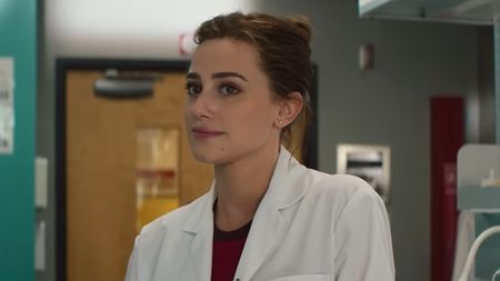 Lili Reinhart as Olive wearing a lab coat and looking forward in The Love Hypothesis. 
