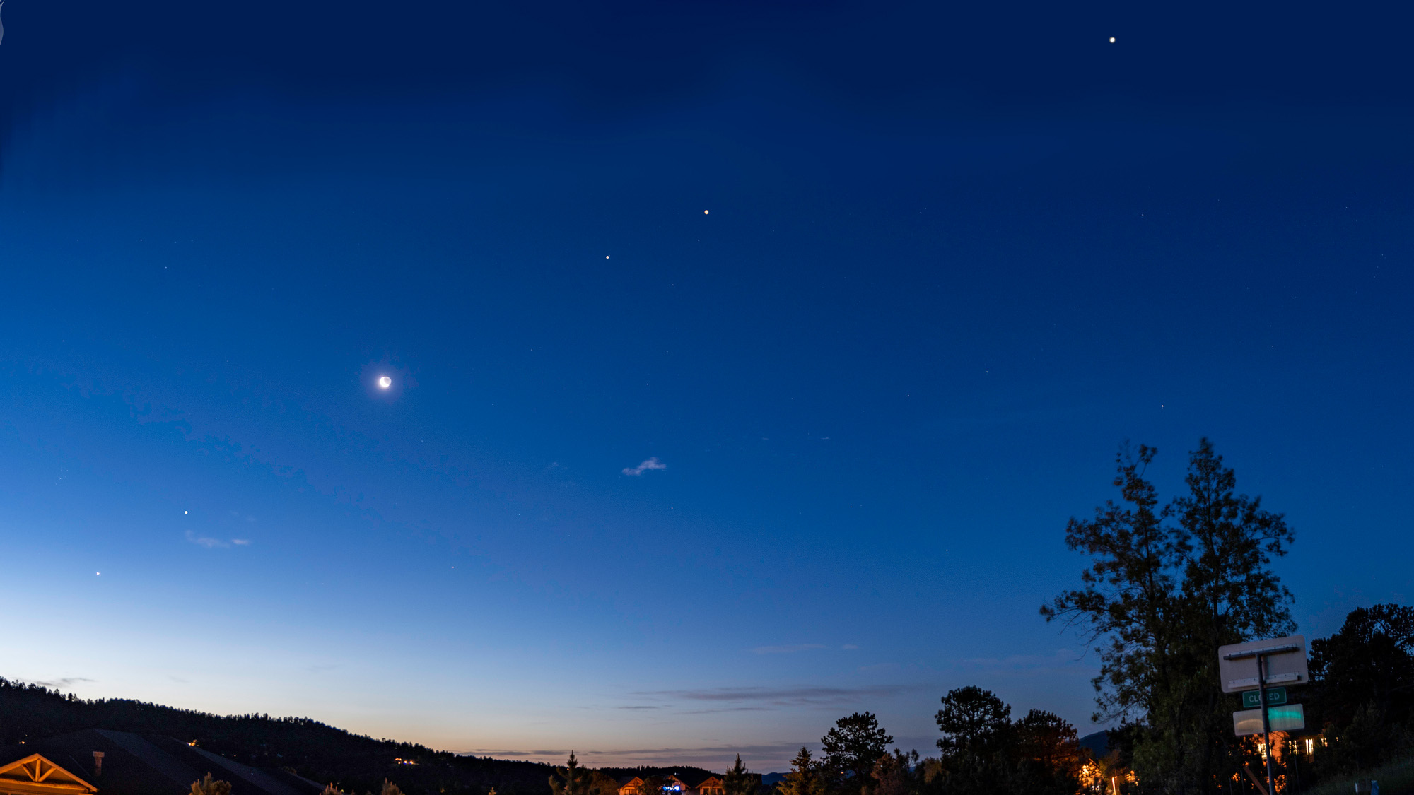 planeary lineup above trees and hills