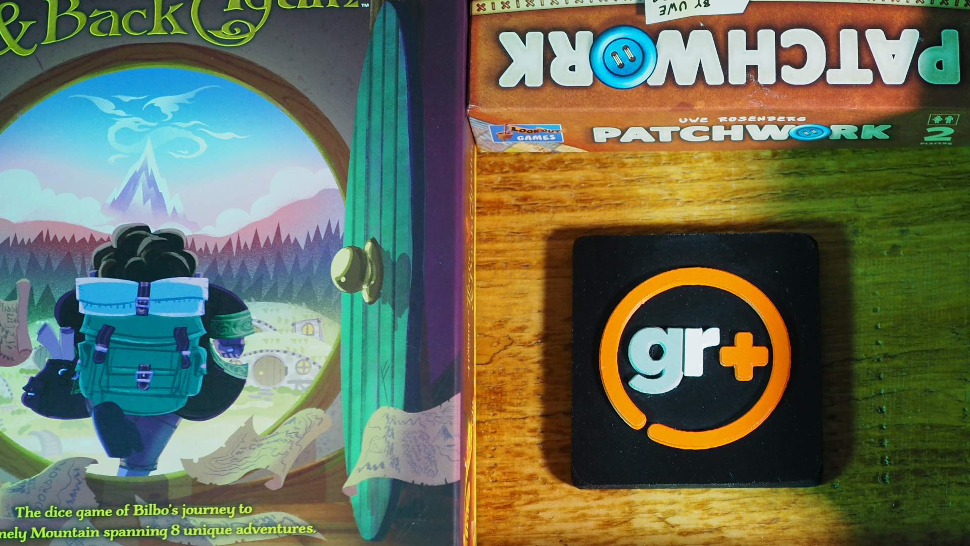A collection of board games surround a GamesRadar+ logo on a wooden surface