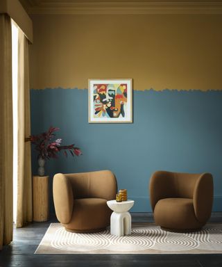 living area with muted dark blue lower half of walls, gold top half with playful rough line detail