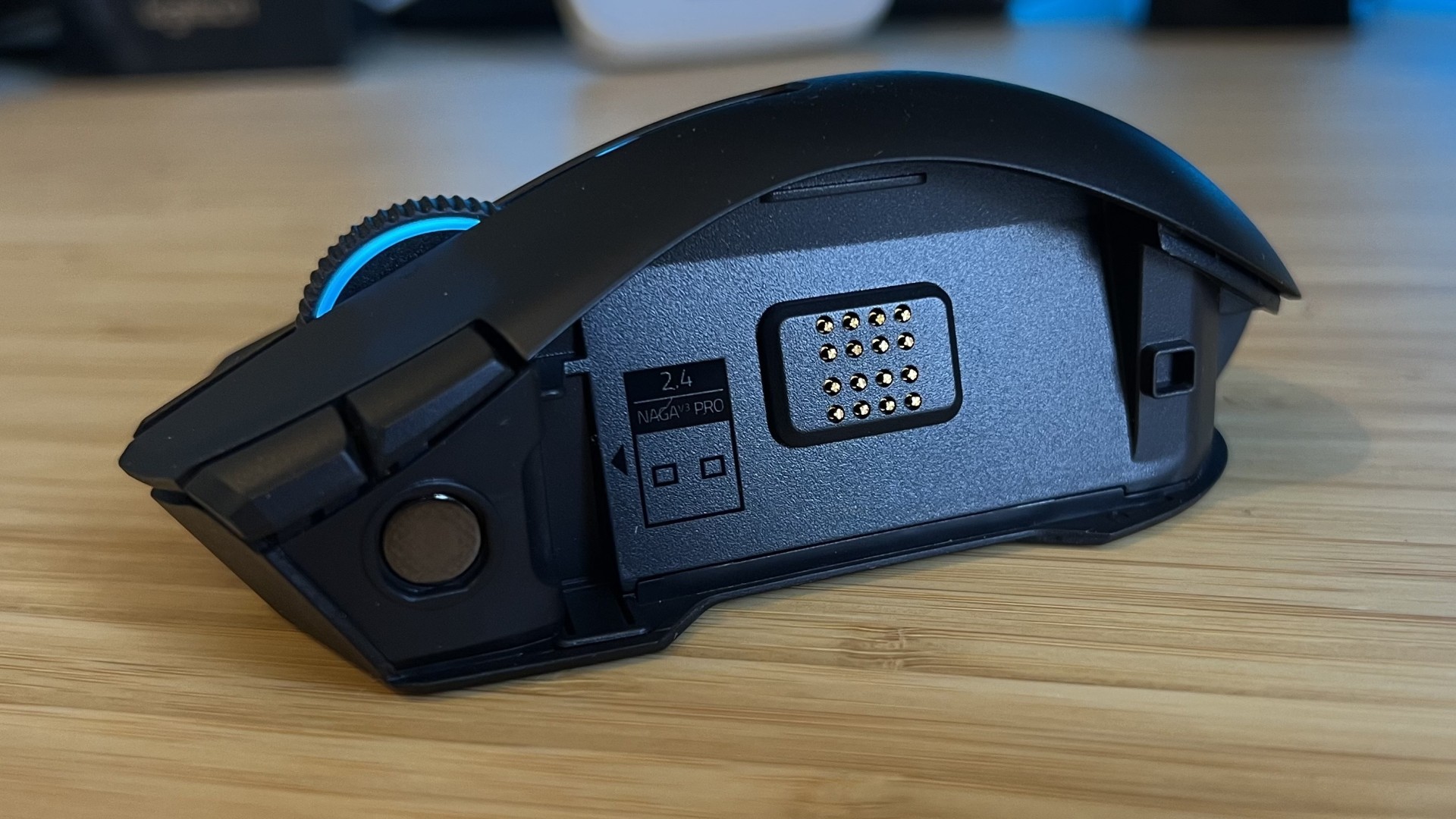 Side view of Razer Naga V3 Pro without any side button panels attached, the magnetic connector and USB dongle housing visible inside