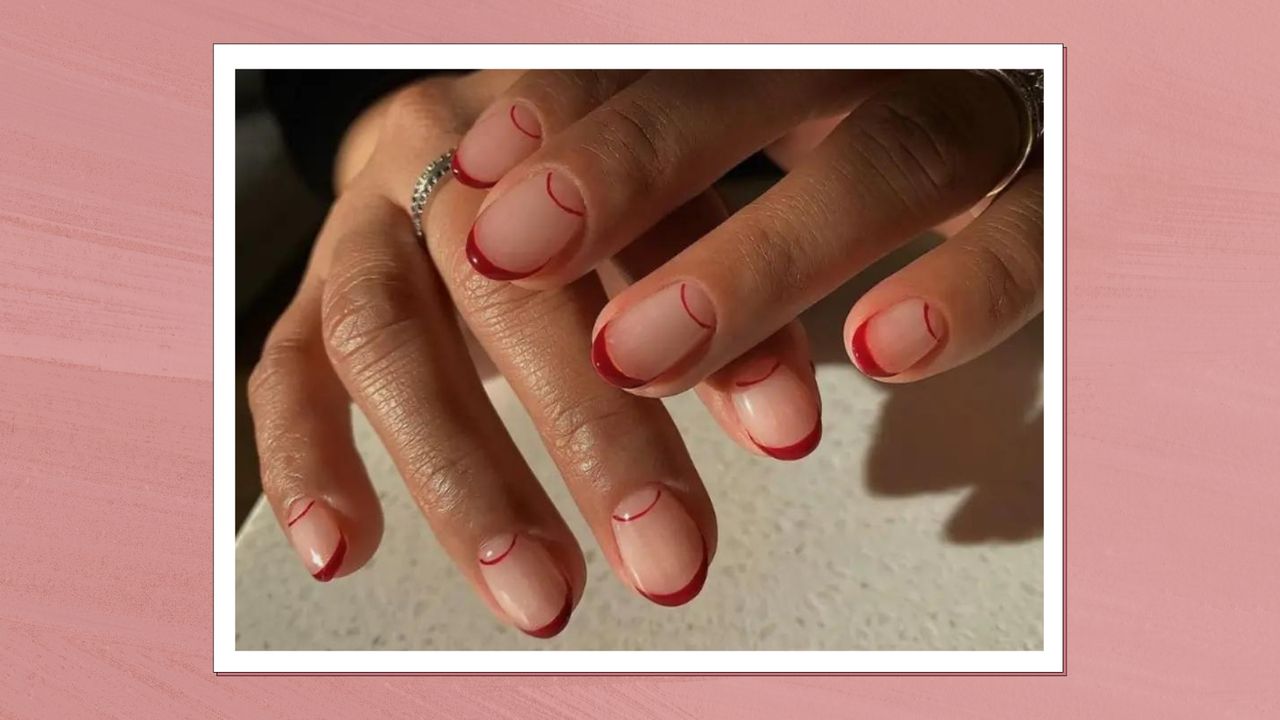 A close up of a hand with rings and double red French tip nails by nail artist @matejanova/Mateja Novakovic/ in a pink textured template