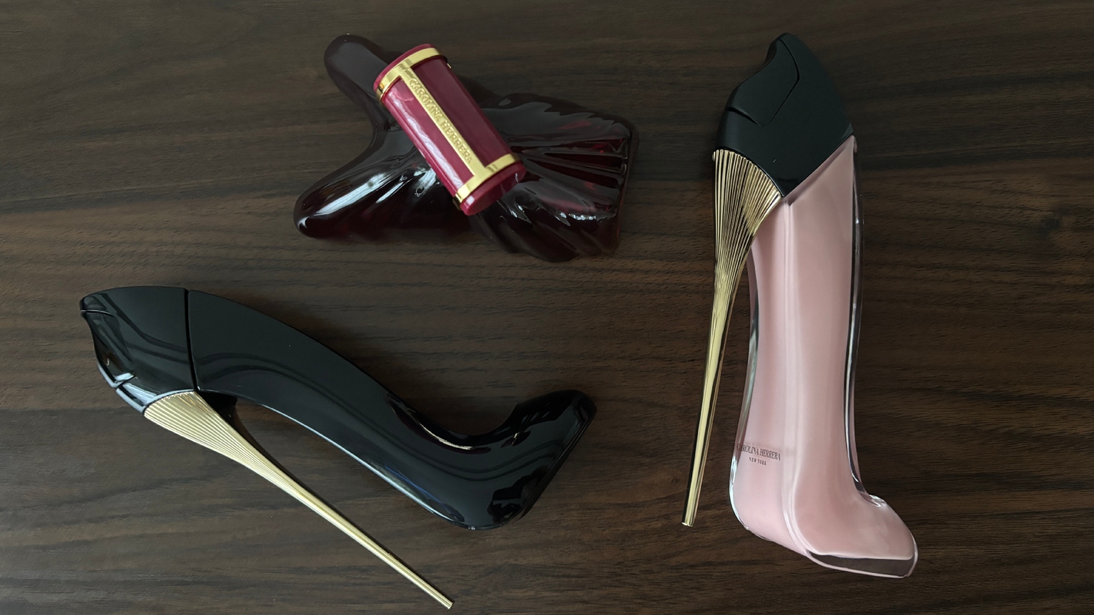 three bottles of Carolina herrera fragrances on a wooden table
