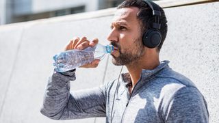 man drinking out of a water bottle during a workout