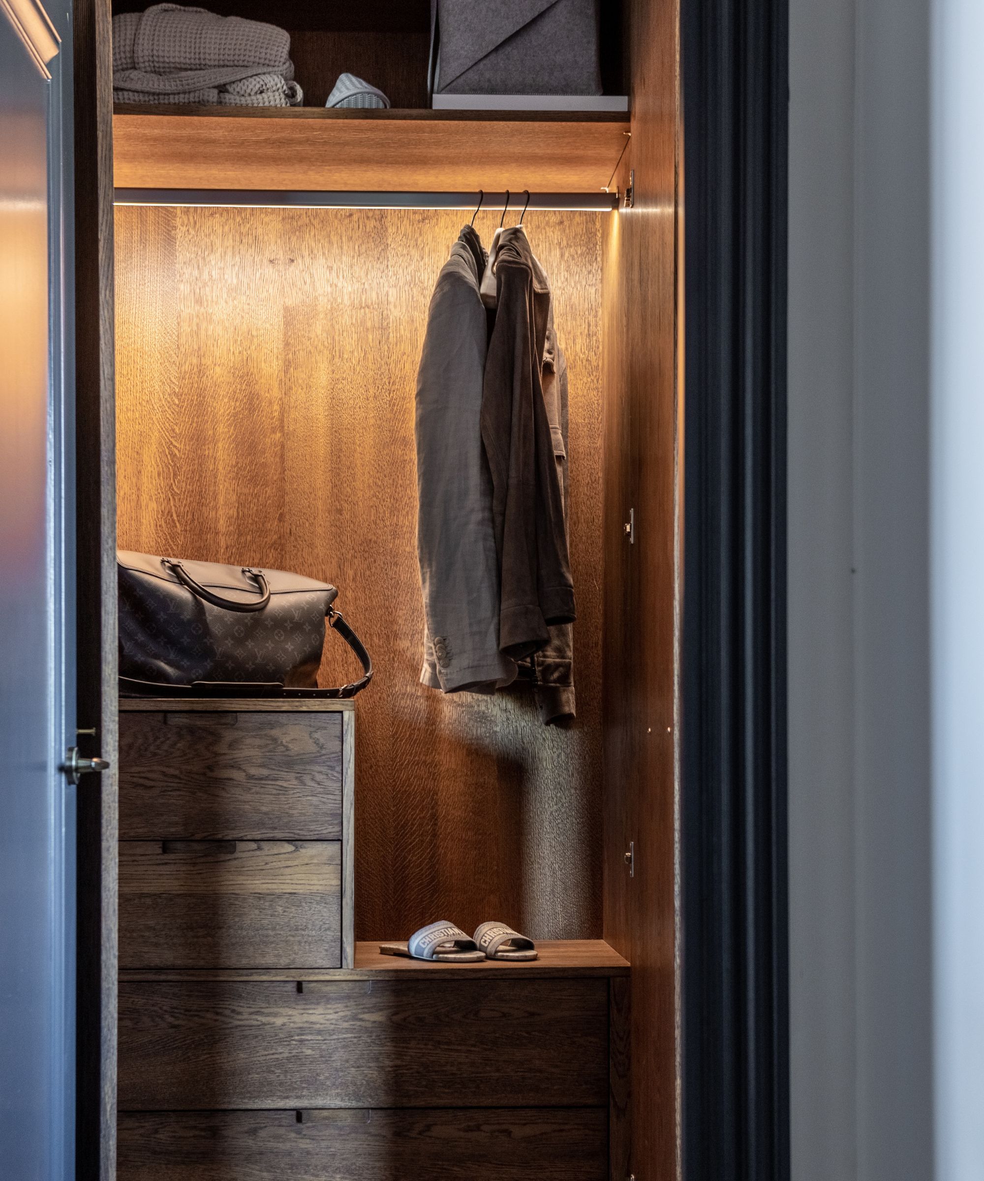 A wardrobe with a singular backlit rail and internal storage