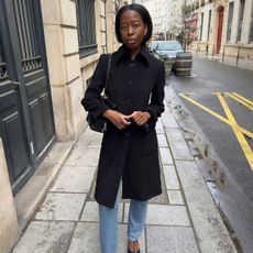 Sylvie Mus wearing a single-breasted coat and jeans.