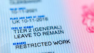 A close up of a UK Tier 2 leave to remain visa, with a "Restricted Work" remark shown