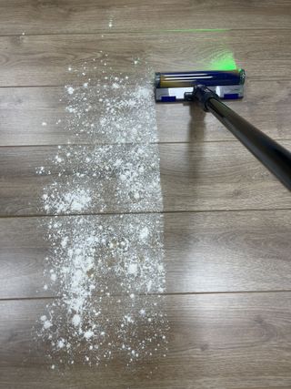 Dyson V12 Detect Slim on wooden floor, vacuuming flour and sugar