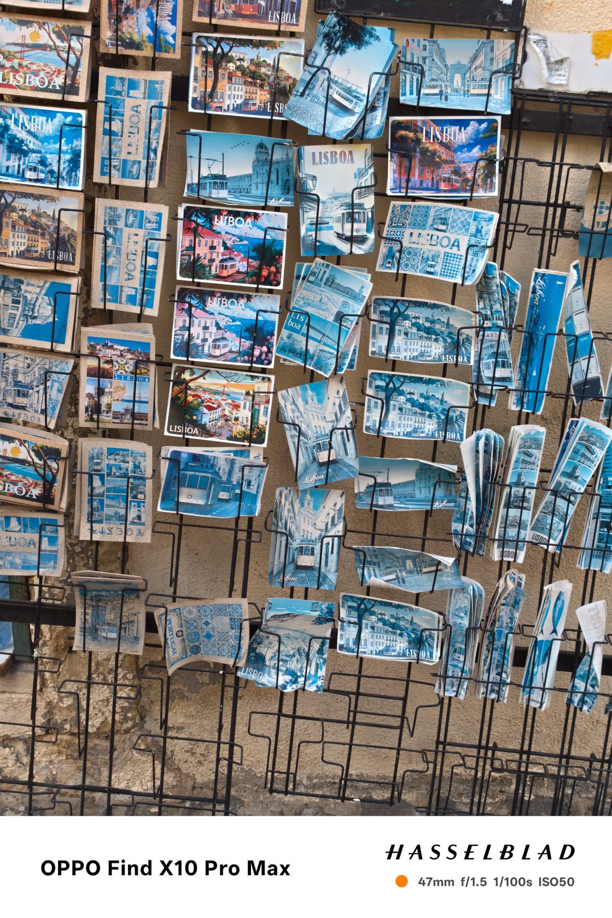 Display rack filled with colorful Lisbon postcards and souvenir prints.