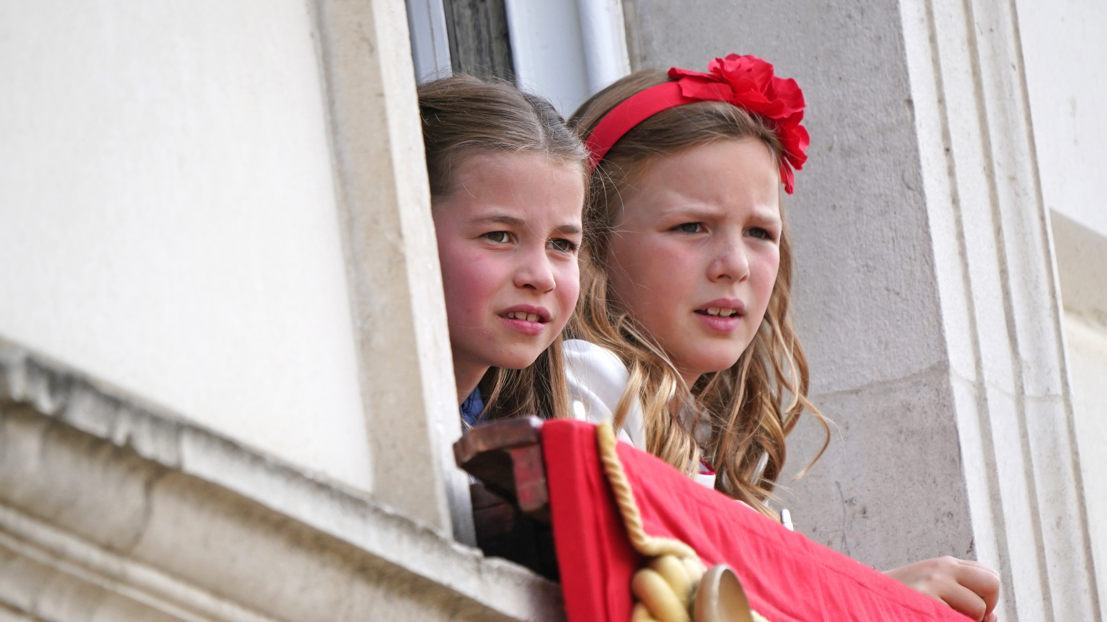 Princess Charlotte (left) and Mia Tindall watch Trooping the Colour from a Buckingham Palace window on June 2, 2022