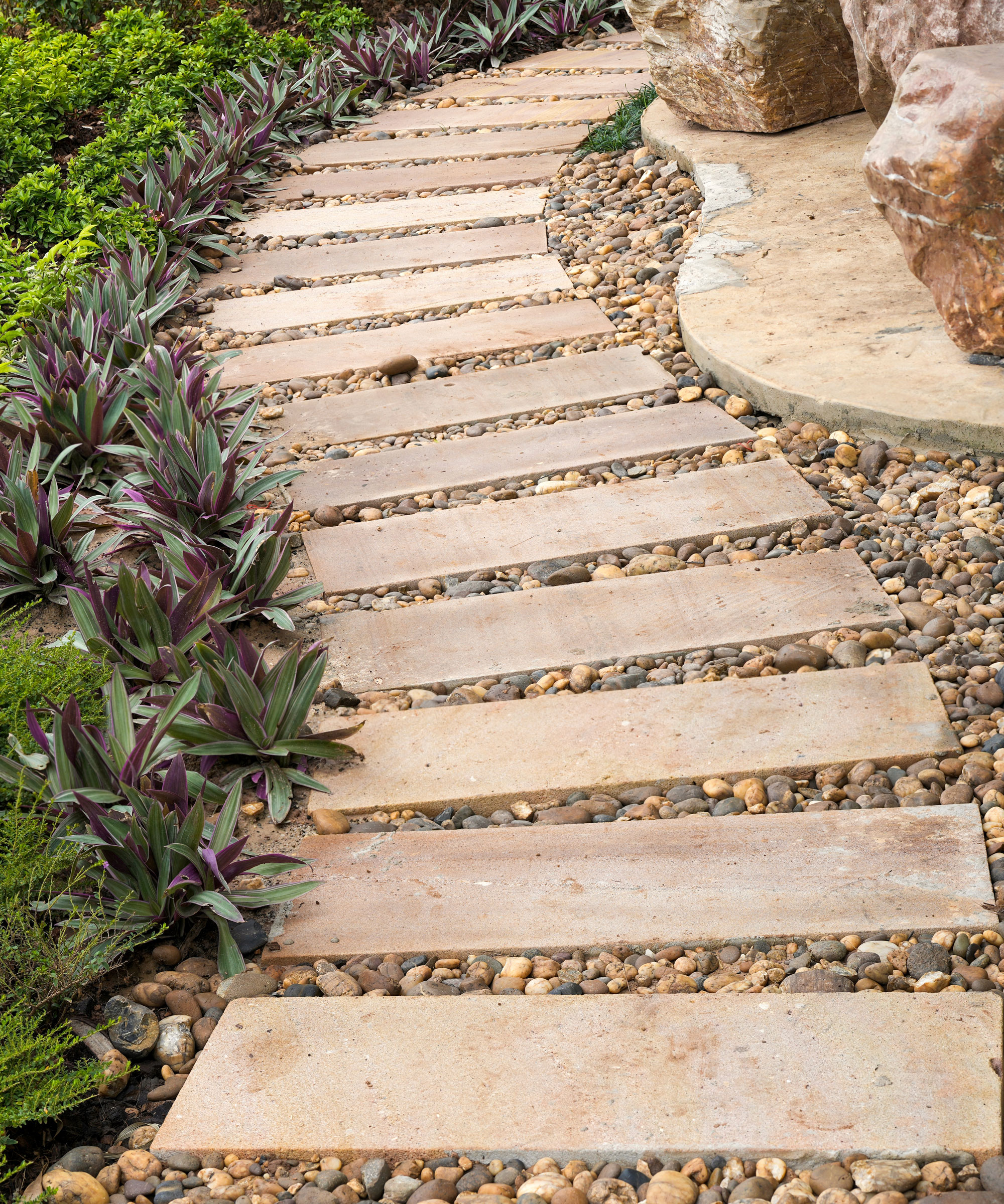 curved path made of rectangular slabs and gravel in back garden
