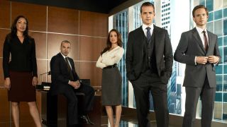A press image of five main characters in the Suits TV show standing in an office
