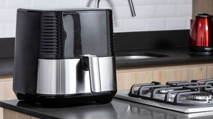 A black and silver air fryer on a kitchen counter
