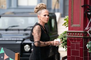 Linda Carter outside the Vic wearing a black dress with spiderwebs on for Halloween.