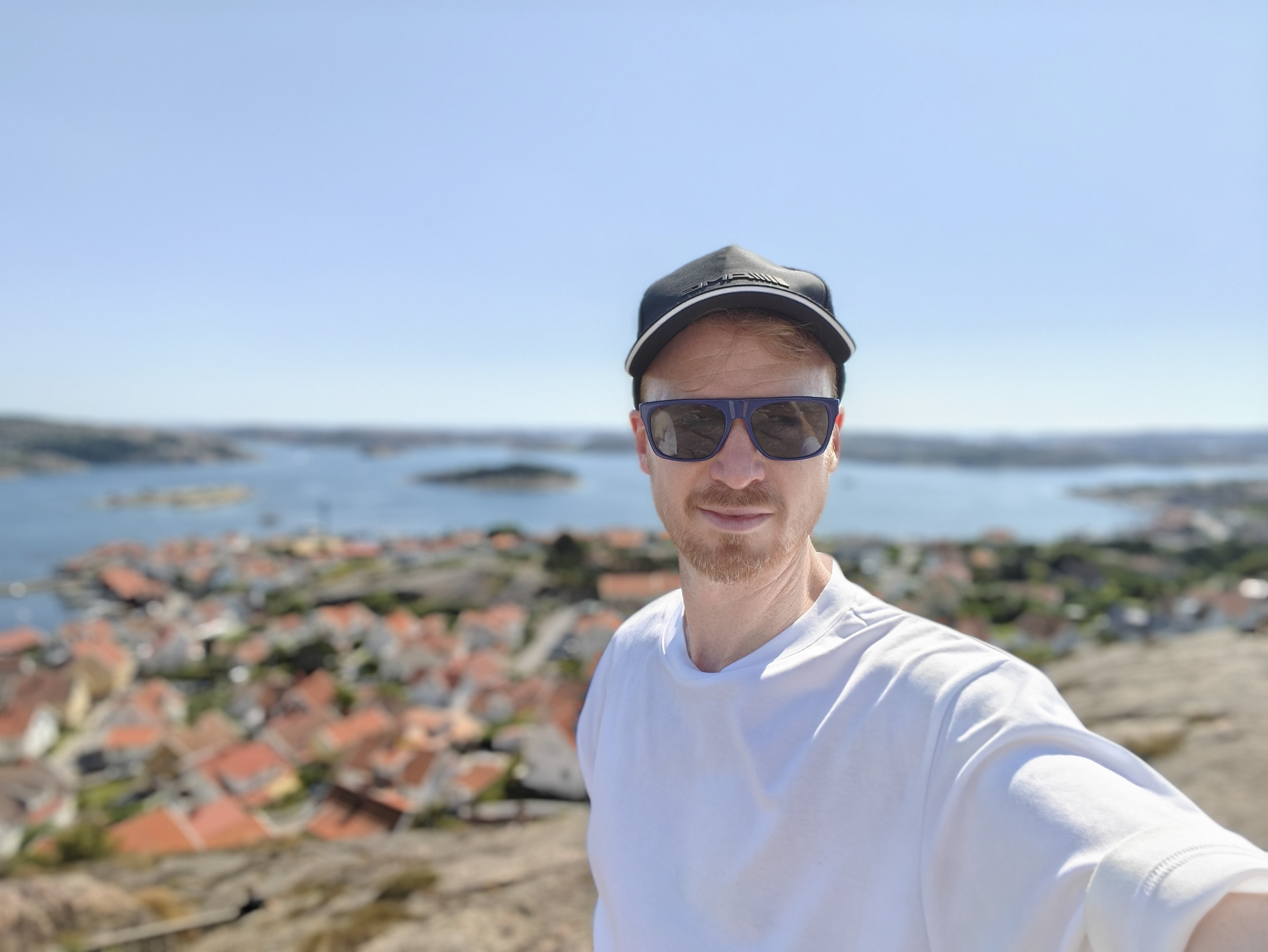 Oppo Find X8 Ultra phone sample image: selfie of a man at a high vantage point over a fishing village