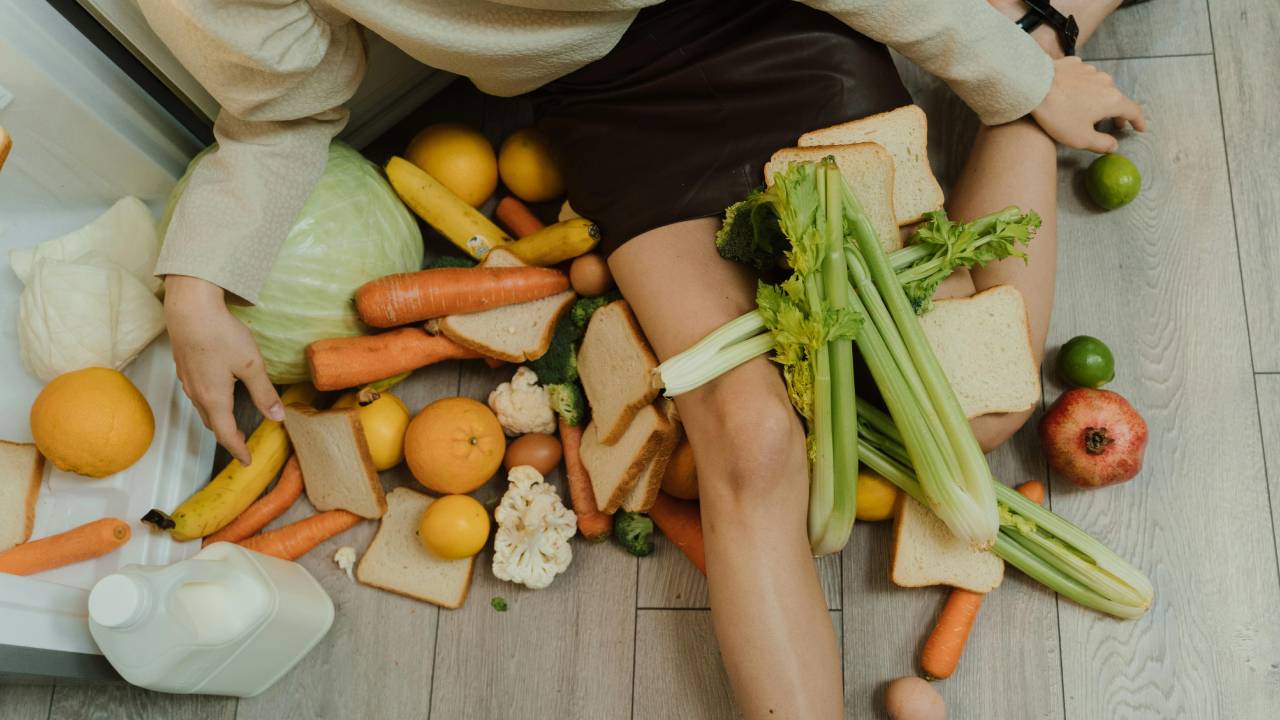 Person sitting on the kitchen floor surrounded by food waste