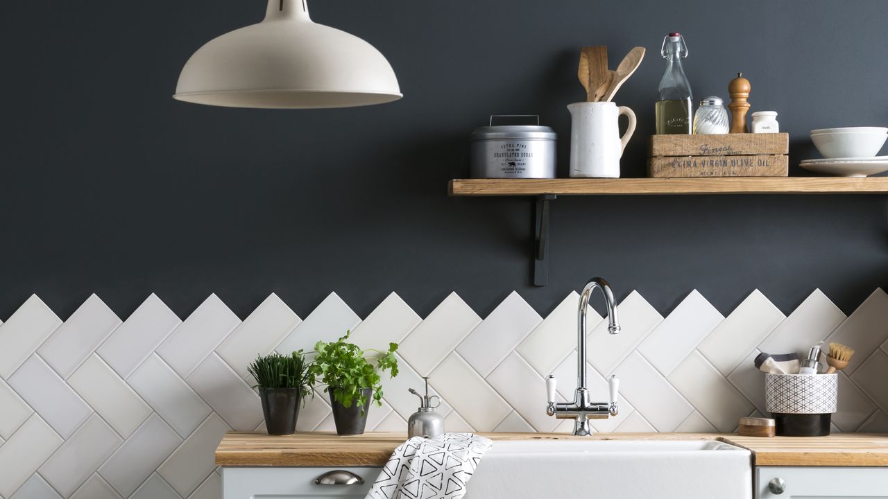 White tiled kitchen backsplash on blue walls with white pendant lamp