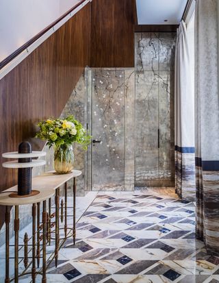 A brightly tiled hallway with console table and flowers