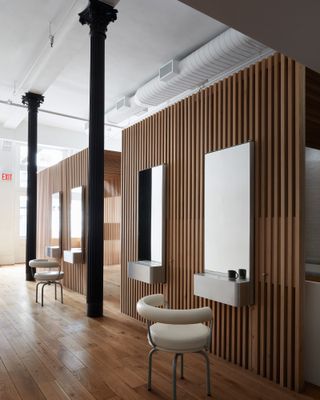 Alternative view of Spiral (x,y,z) featuring vertical wood slats, black columns, four rectangle mirrors and chairs