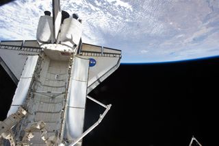 The docked space shuttle Endeavour is featured in this image photographed by an STS-134 crew member onboard the International Space Station on May 21, 2011 during flight Day 6 activities. Earth's horizon and the blackness of space provide the backdrop for