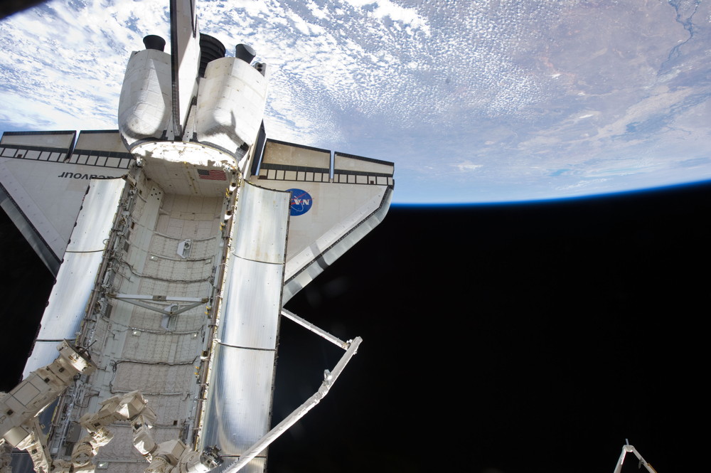 The docked space shuttle Endeavour is featured in this image photographed by an STS-134 crew member onboard the International Space Station on May 21, 2011 during flight Day 6 activities. Earth&#039;s horizon and the blackness of space provide the backdrop for