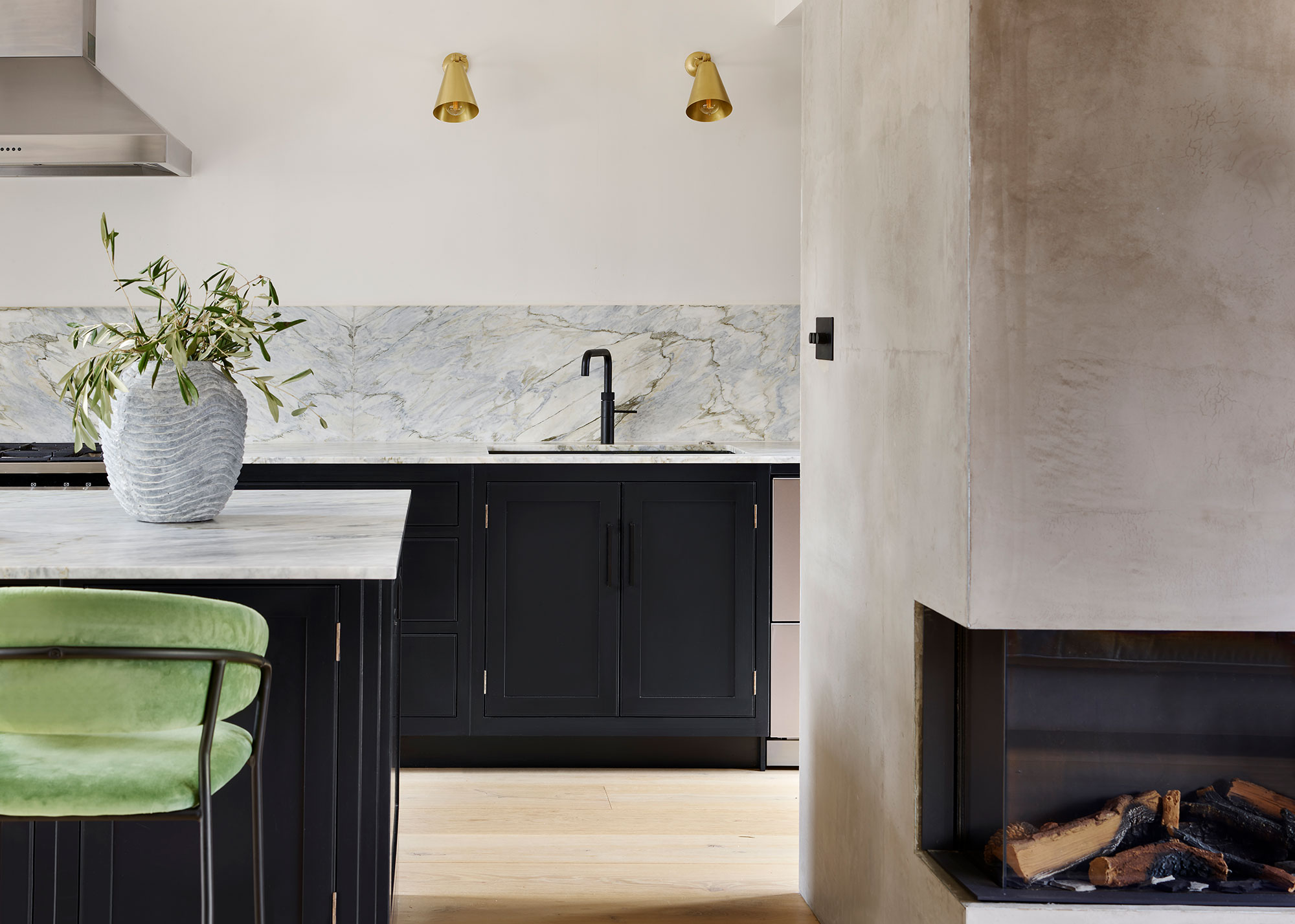 navy kitchen with green bar stools and marble backsplash