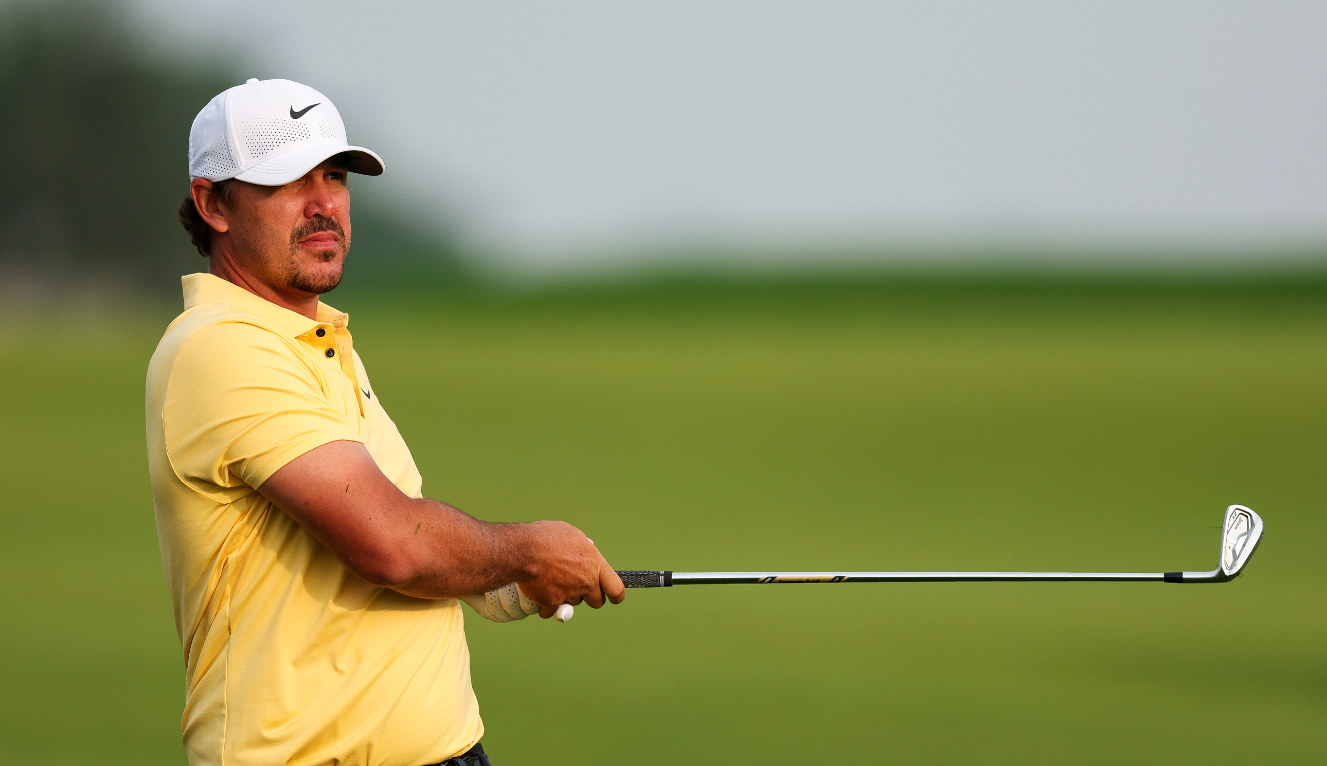 Brooks Koepka watches an iron shot