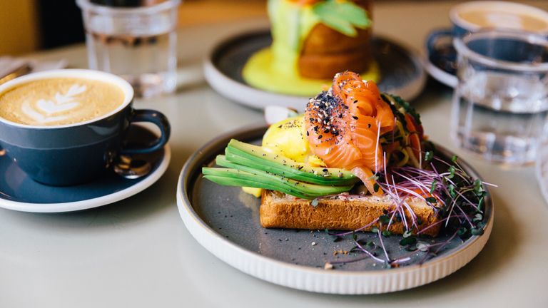 Avocado toast with salmon and poached egg served for breakfast at a cafe