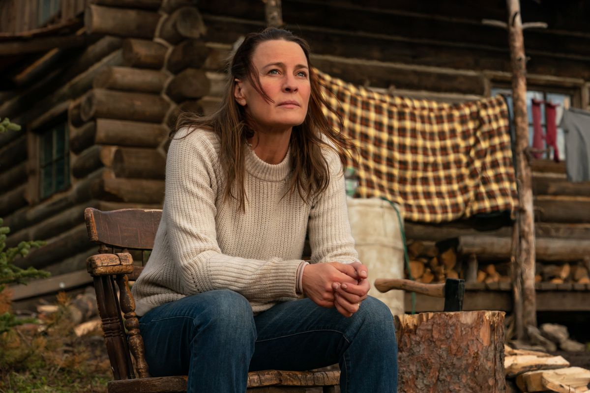 Edee (Robin Wright) sits on the steps leading to her cabin. 