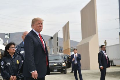 Trump stands in front of border wall prototypes.