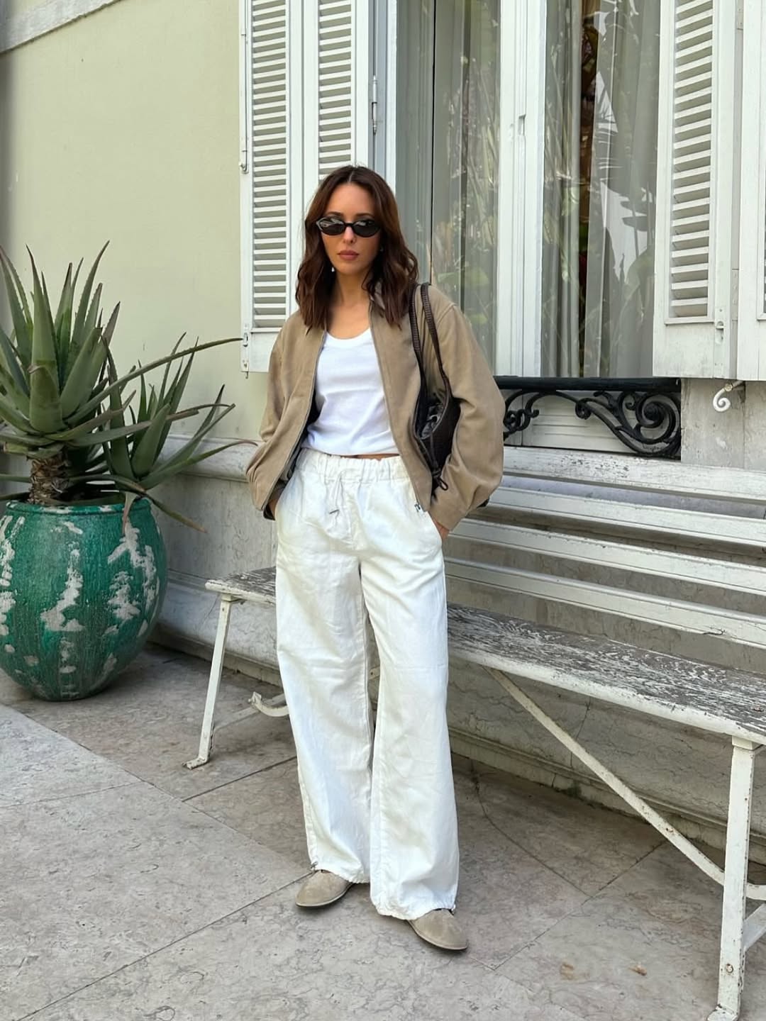Stylist Debora Brosa wears a Birkenstock Boston Clog, white jeans, white t-shirt, brown jacket