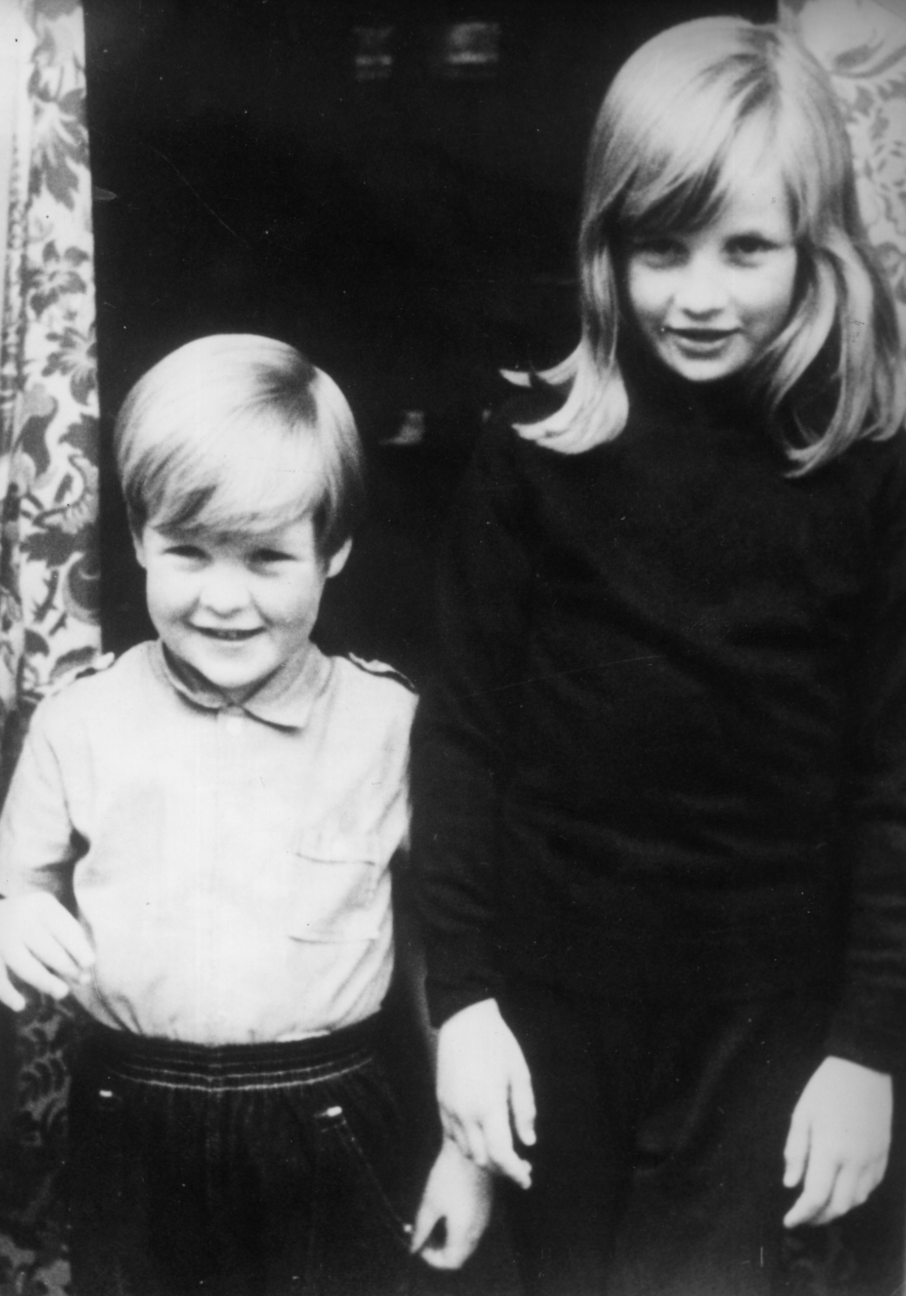 Charles and Diana Spencer standing next to each other as children