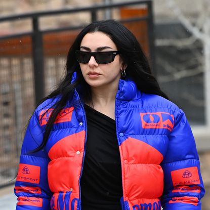 Charli XCX attending Sundance Film Festival wearing Saint Laurent, a puffer jacket, jeans, and Ugg boots