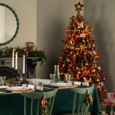A dining room decorated for Christmas with a Christmas tree in the corner