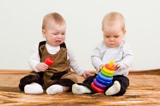 children sharing toy