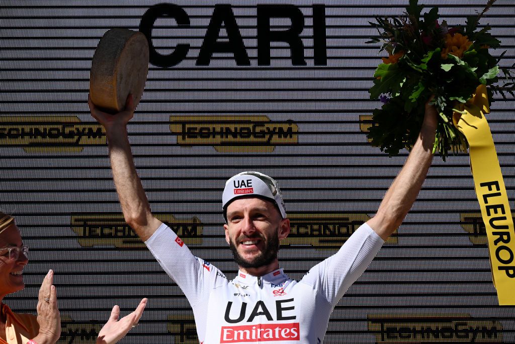 CARI SWITZERLAND JUNE 13 Adam Yates of The United Kingdom and UAE Team Emirates celebrates at podium as stage winner during the 87th Tour de Suisse 2024 Stage 5 a 1486km stage from Ambri to Cari 1636m UCIWT on June 13 2024 in Cari Switzerland Photo by Tim de WaeleGetty Images