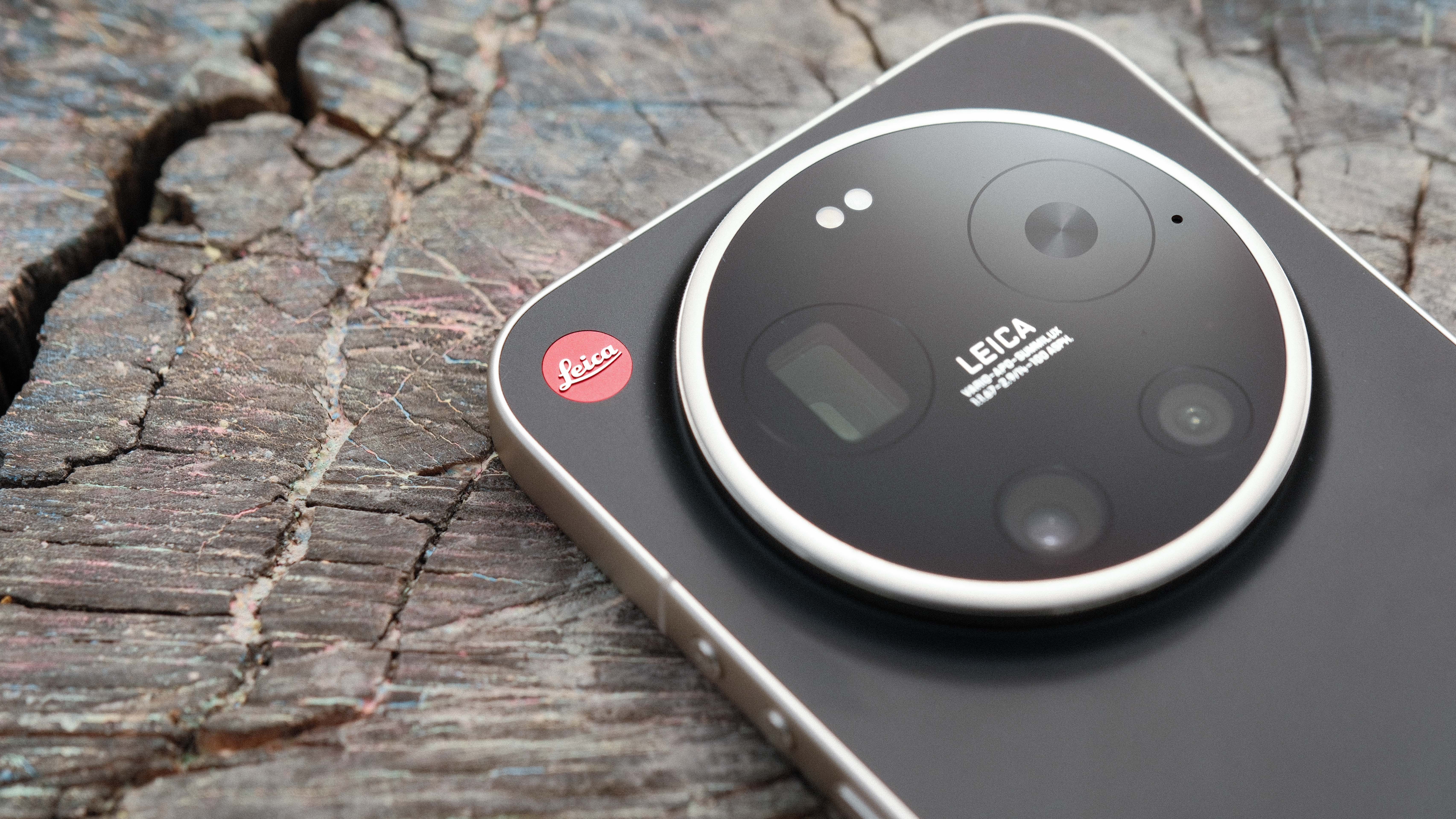 Close-up of the Leica Leitz Phone camera module on a wooden surface