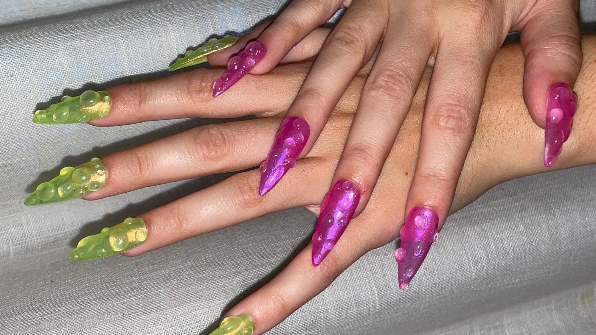 Charli XCX wearing jelly acrylic nails with water droplets.