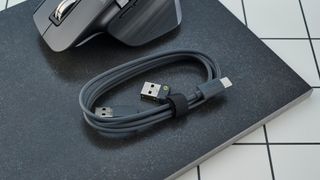 A photo of the Logitech MX Master 3S cables on a black slate against a blue background.