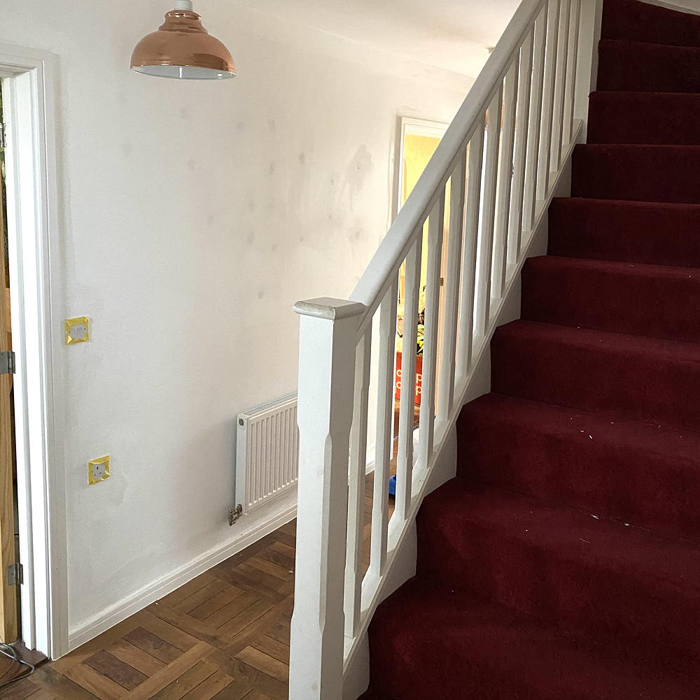 hallway with red carpet and staircase