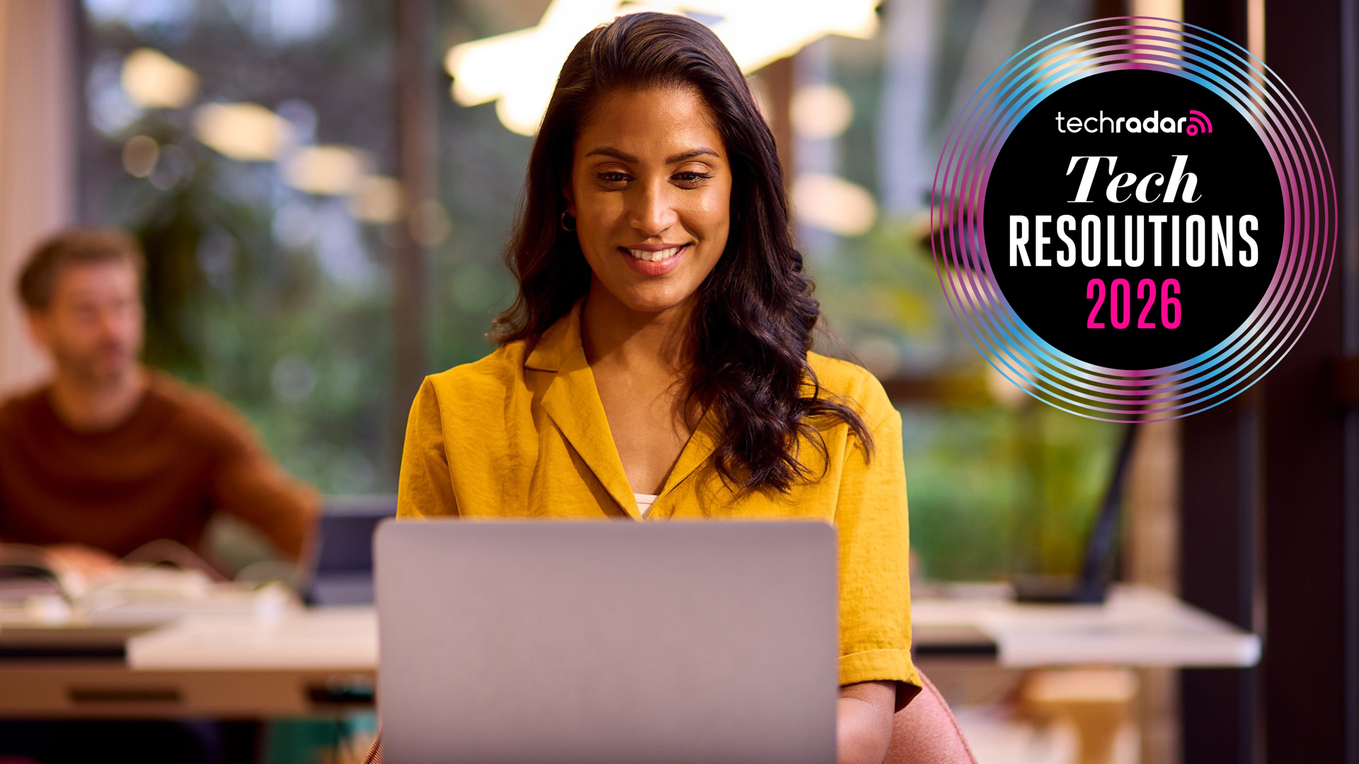 A young woman is working on a laptop in a relaxed office space.