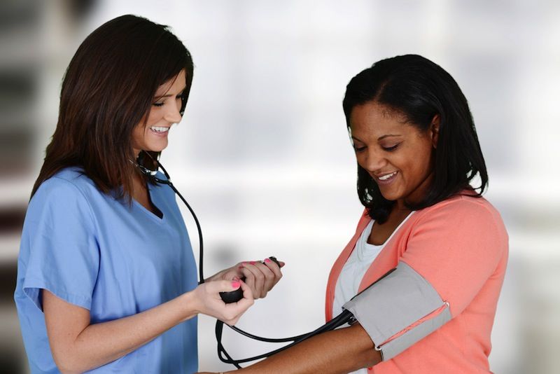 A woman has her blood pressure checked.