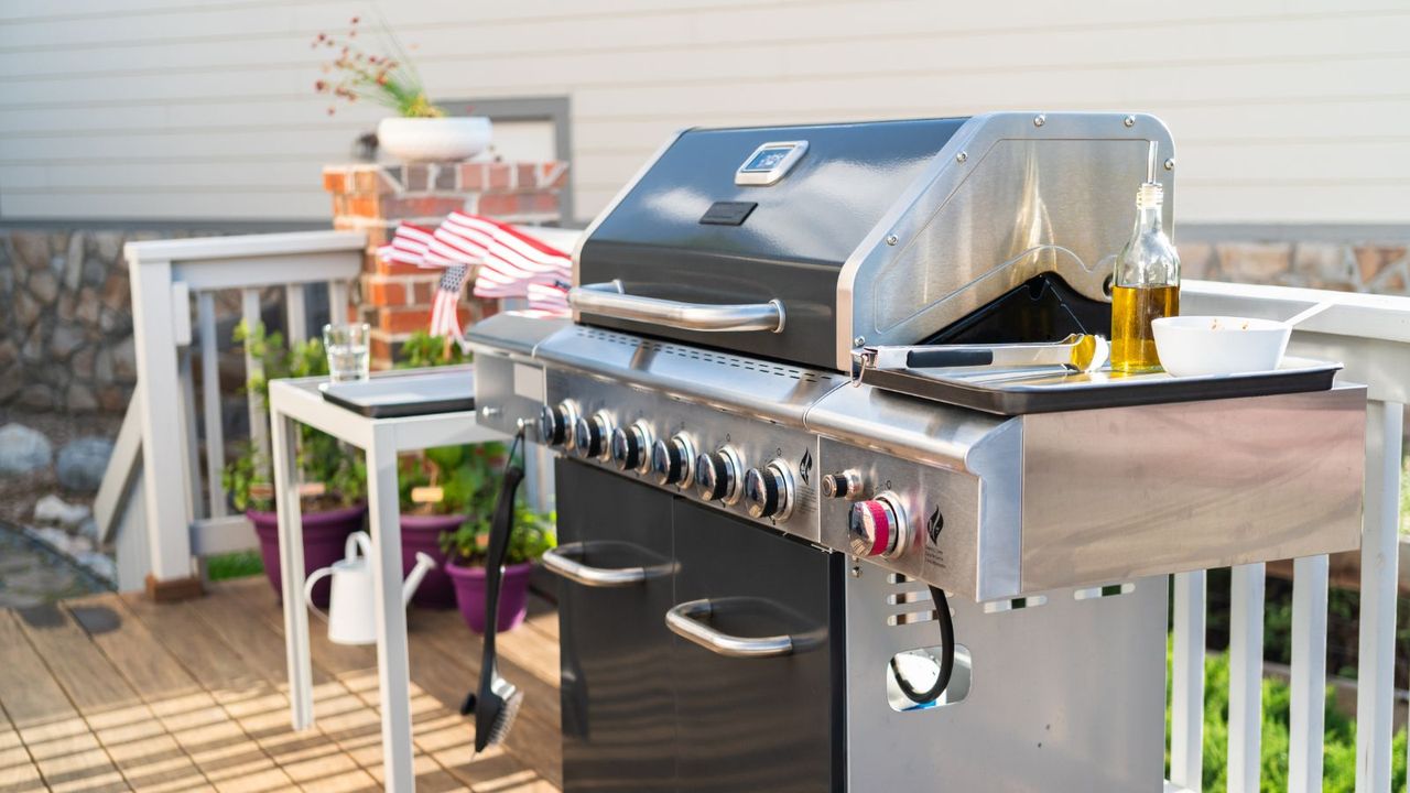 A large gas grill on a deck