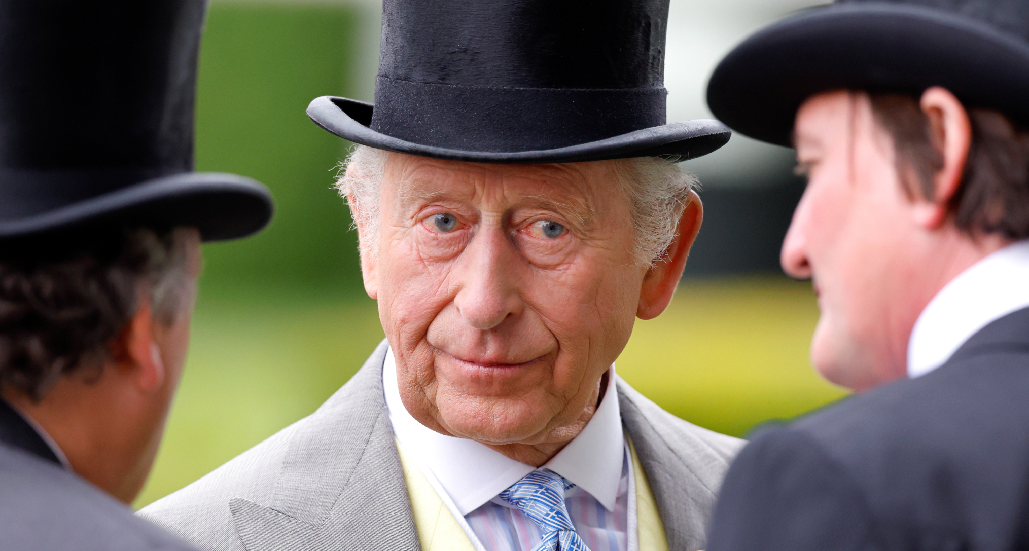 King Charles wearing a top hat and suit