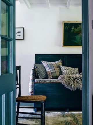 Landing with white walls and dark bench with cushions