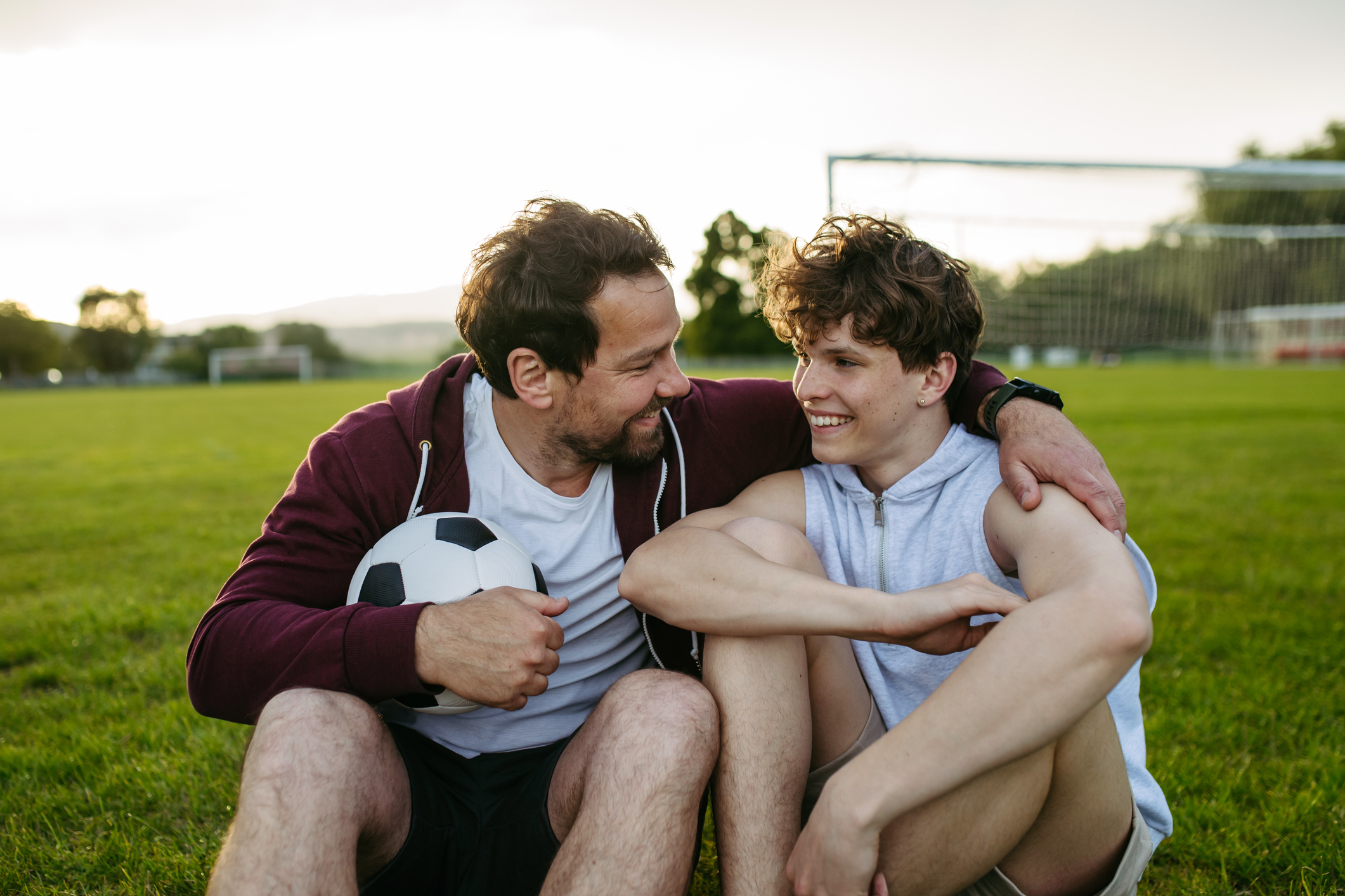 A happy father and son playing football together.