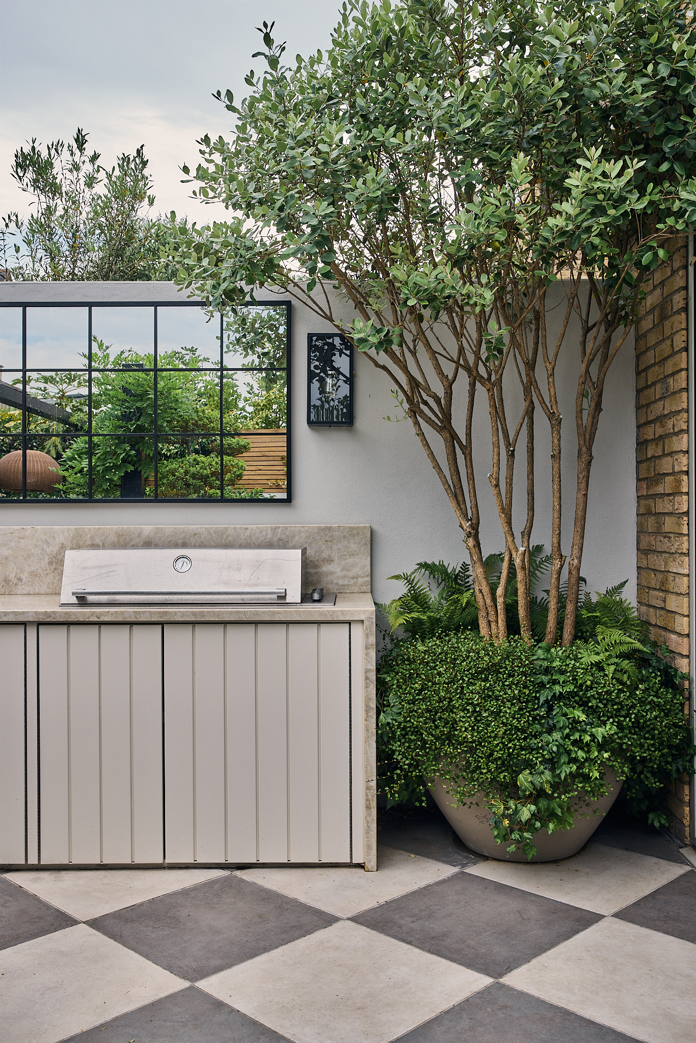 a modern garden filled with plants with a large checkerboard floor