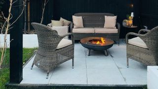 light coloured patio with dark stained fence and firepit