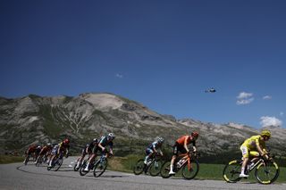 UAE Team Emirates team's Slovenian rider Tadej Pogacar wearing the overall leader's yellow jersey cycles with the pack of riders (peloton) in the descent of the Col du Festre during the 18th stage of the 111th edition of the Tour de France cycling race, 179,5 km between Gap and Barcelonnette, in the French Alps in southeastern France, on July 18, 2024. (Photo by Anne-Christine POUJOULAT / AFP) (Photo by ANNE-CHRISTINE POUJOULAT/AFP via Getty Images)